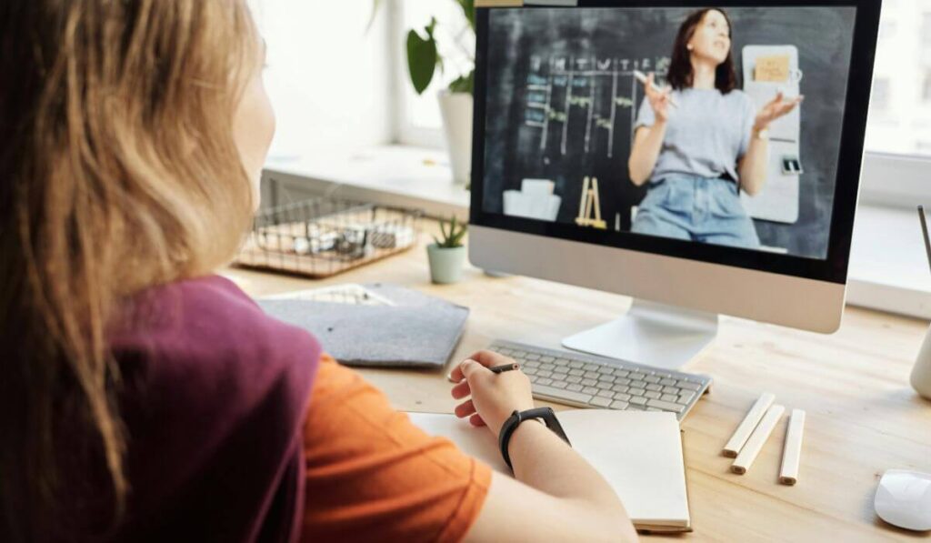 photo of student watching tutor on computer in online french classes