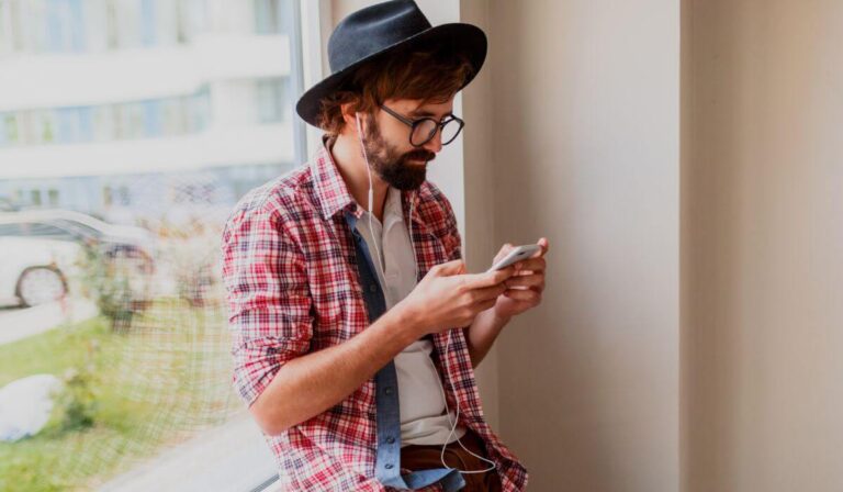 photo of man using language learning apps on phone