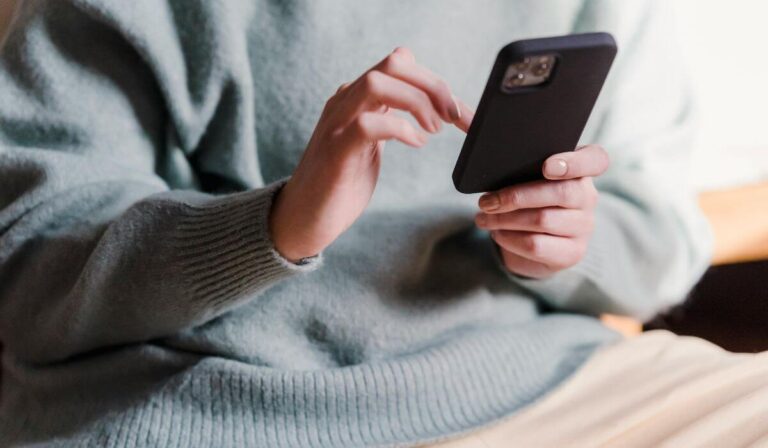 close up shot of woman using language learning apps on phone